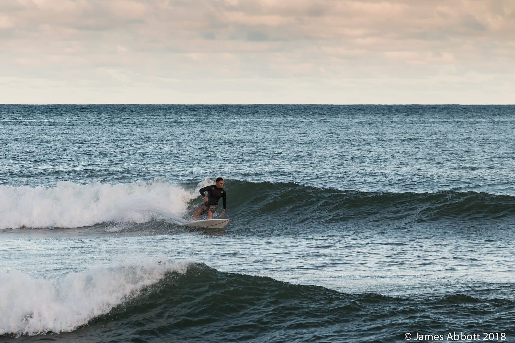 A surfer riding a wave off Kalapakī Beach in Līhuʻe