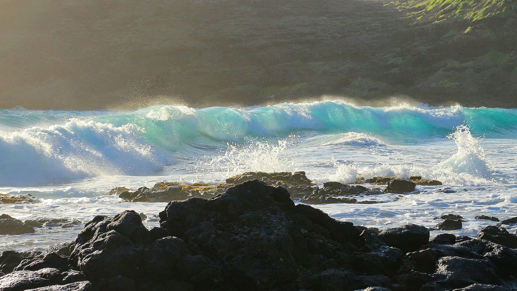 Turquoise shorebreak rolling over lava rock at Makapuʻu Beach Park