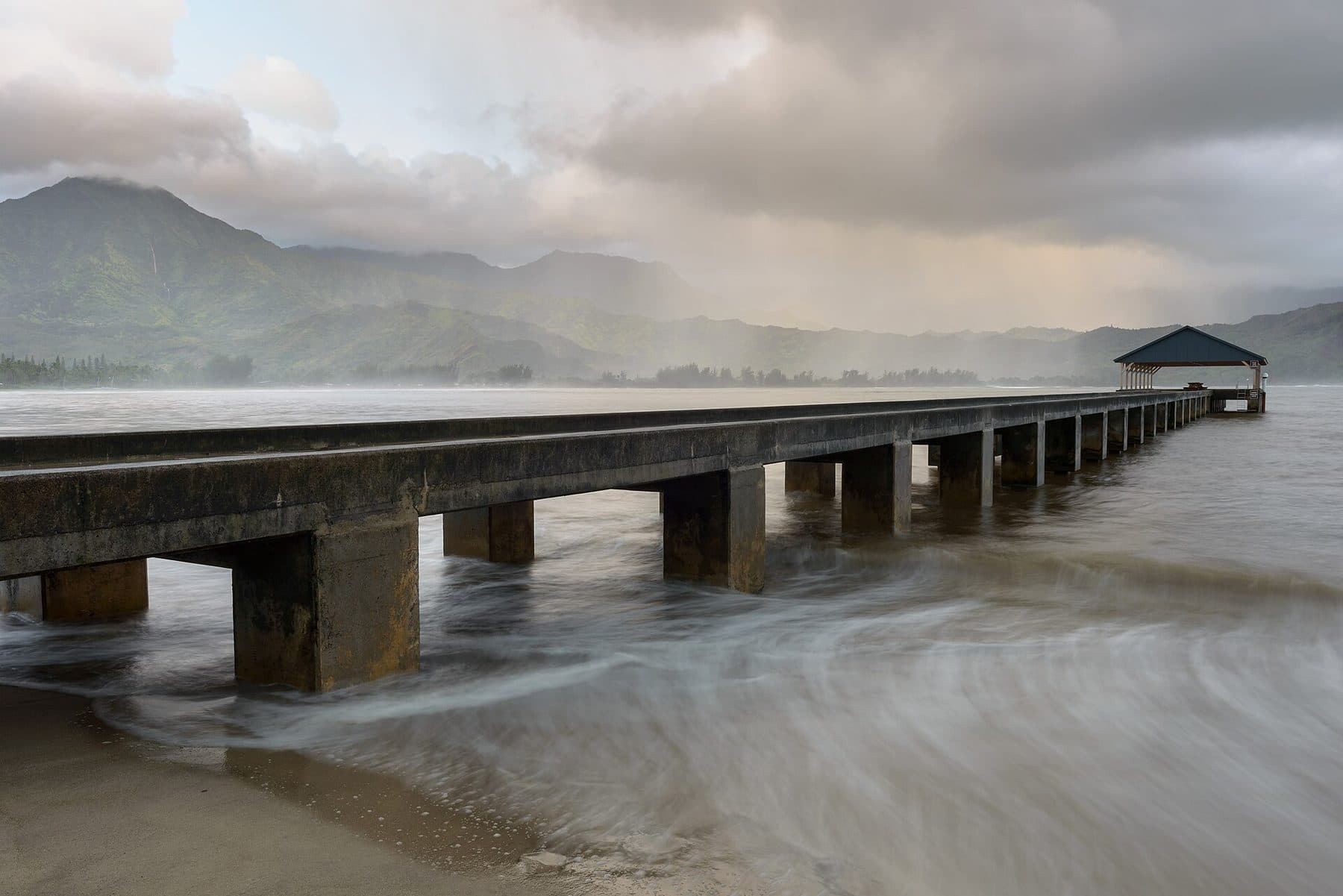 Hanalei Pier reaching into Hanalei Bay under the North Shore mountains