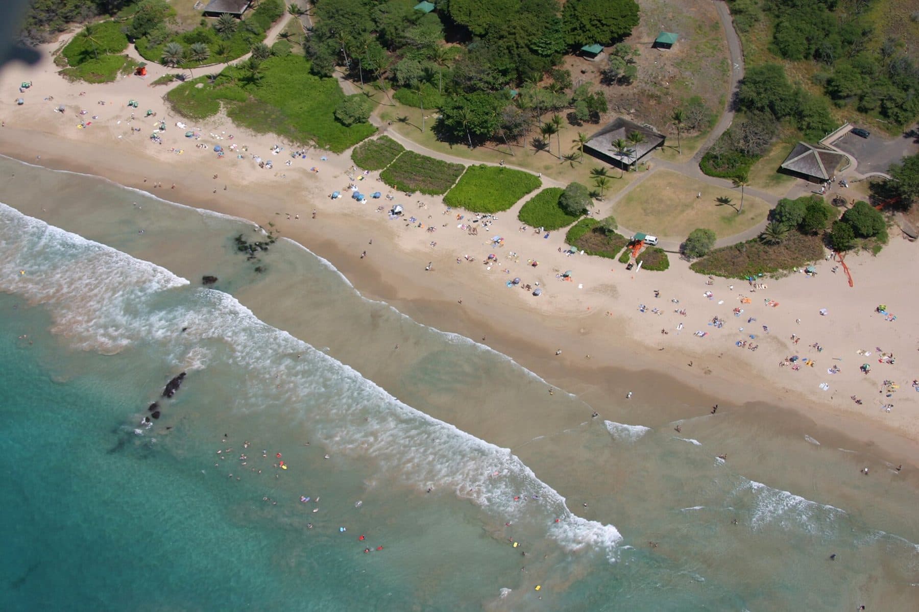 Aerial view of Hāpuna Beach’s long white-sand curve and turquoise surf on the Kohala Coast