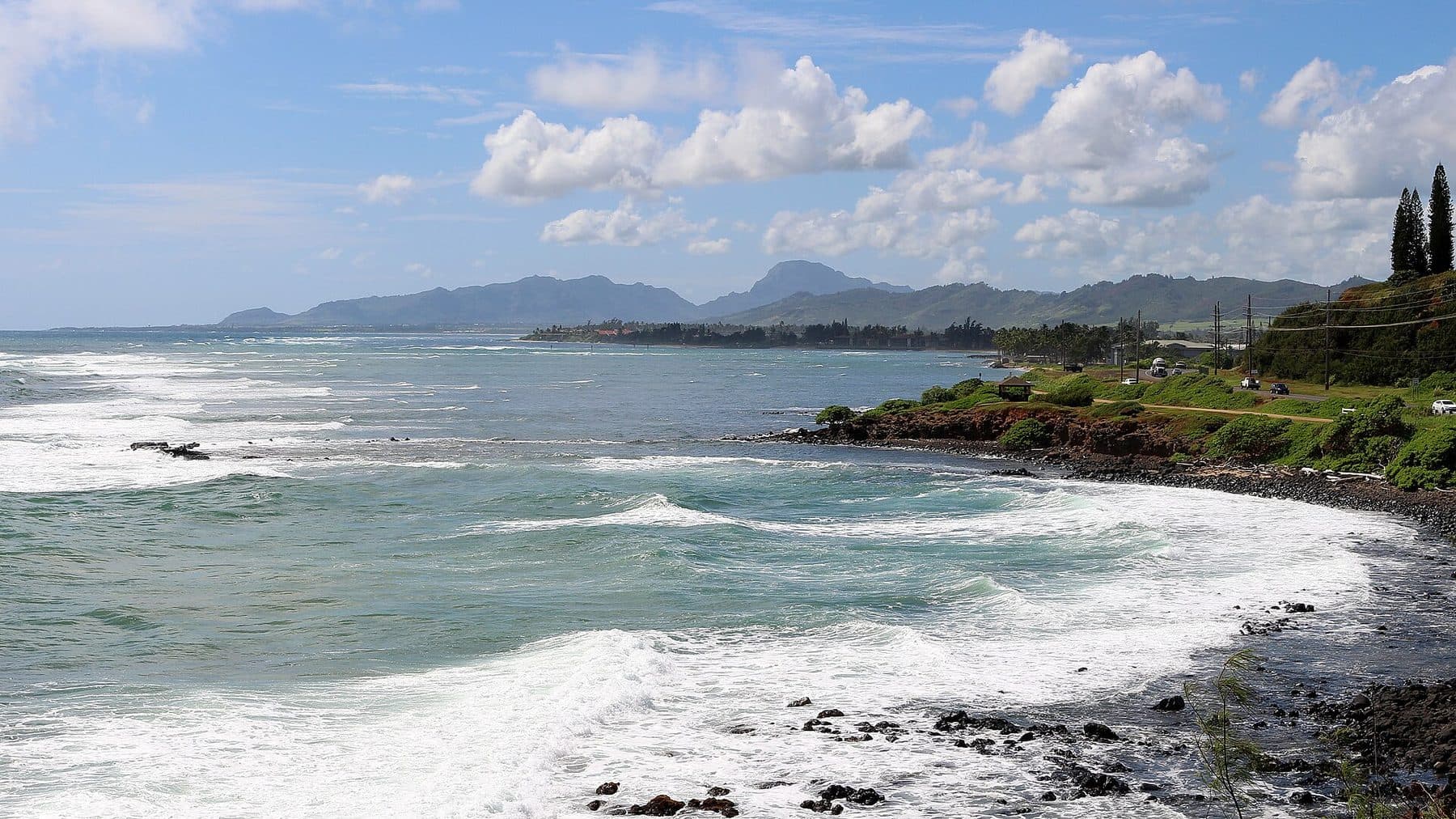 Surf breaking along the Kapaʻa coast beside the coastal path